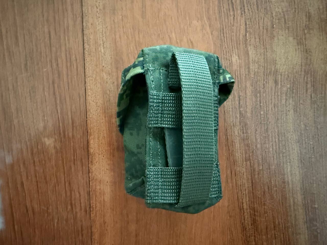 Green tactical pouch on a wooden surface
