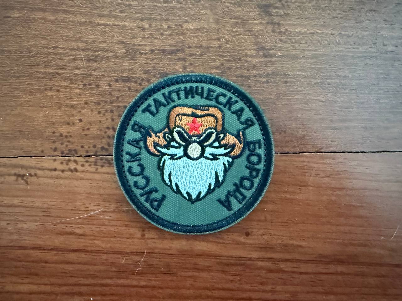 Circular patch with embroidered design on a wooden surface