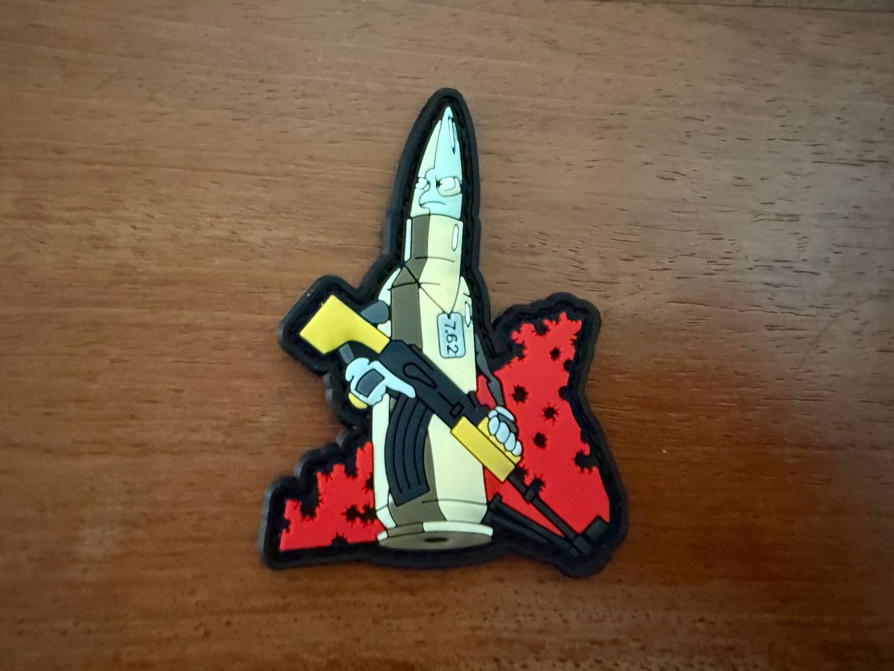 Colorful patch with a design of a character holding a weapon on a wooden surface