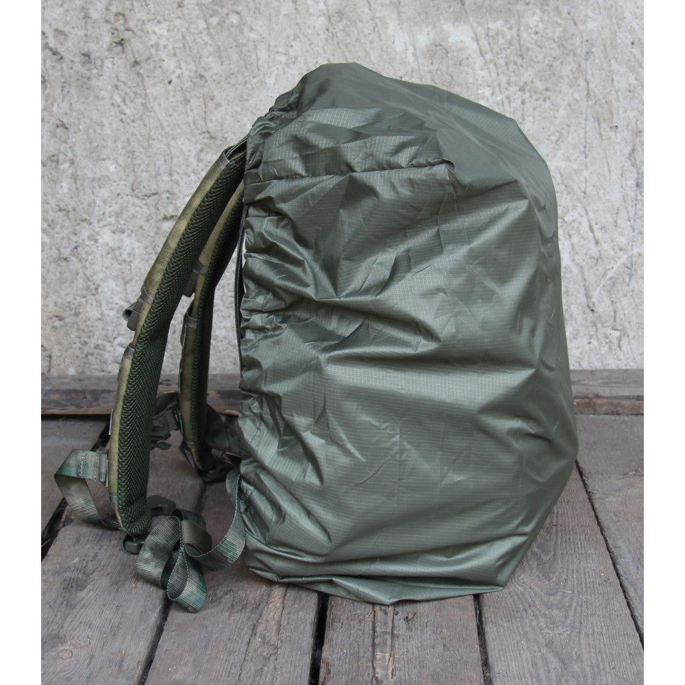 Green backpack with cover on a wooden surface