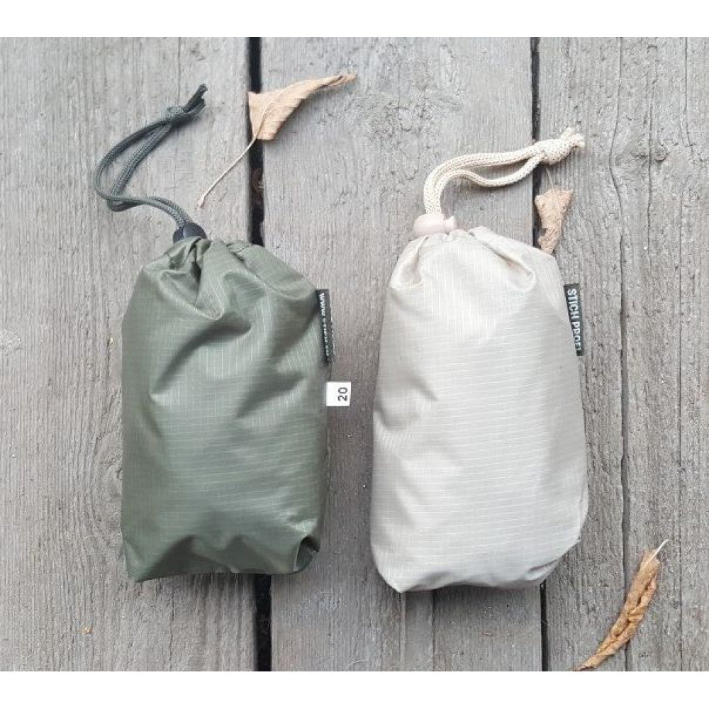 Two drawstring bags, one green and one beige, on a wooden surface.