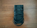 Russian Suppressor Cover for Tactical Silencers - 14cm Length - Black, shown rolled and secured with a drawstring, placed on a wooden surface.