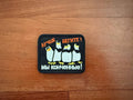 A rectangular military badge from Tanki Stores Better Run! We Are Done! Penguins Patch set lies on wood, featuring four cartoon penguins in a row with Russian text above and below them.