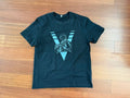 Black T-Shirt with Russian Soldier and Army Symbol - Front Print (Size XL) featuring a front print of a soldier in tactical gear over a large stylized V symbol on a wooden floor background.