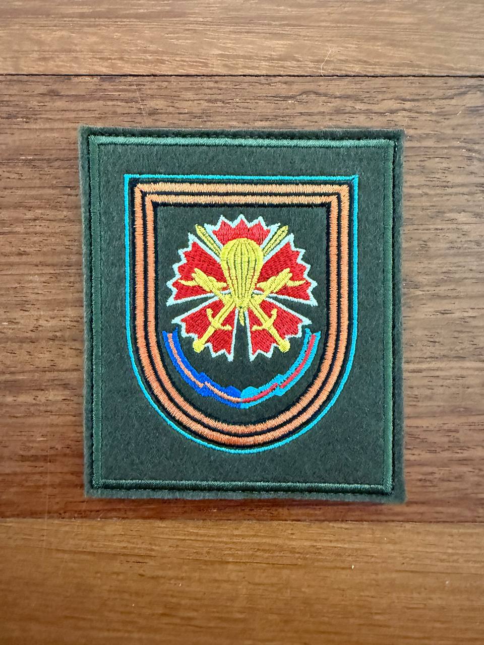 Embroidered patch with a colorful design on a wooden surface