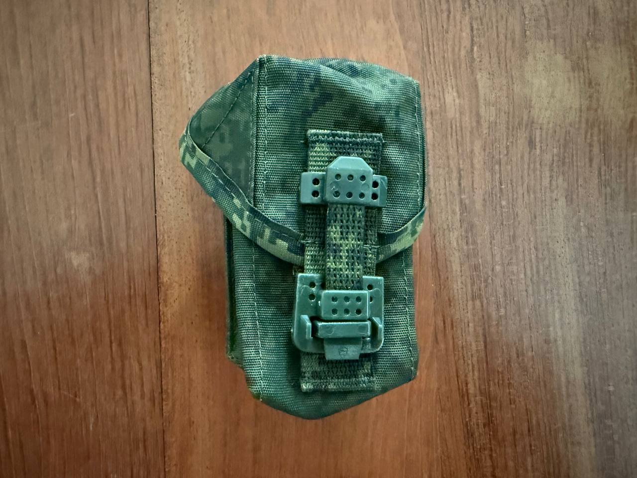 Green tactical pouch on a wooden surface