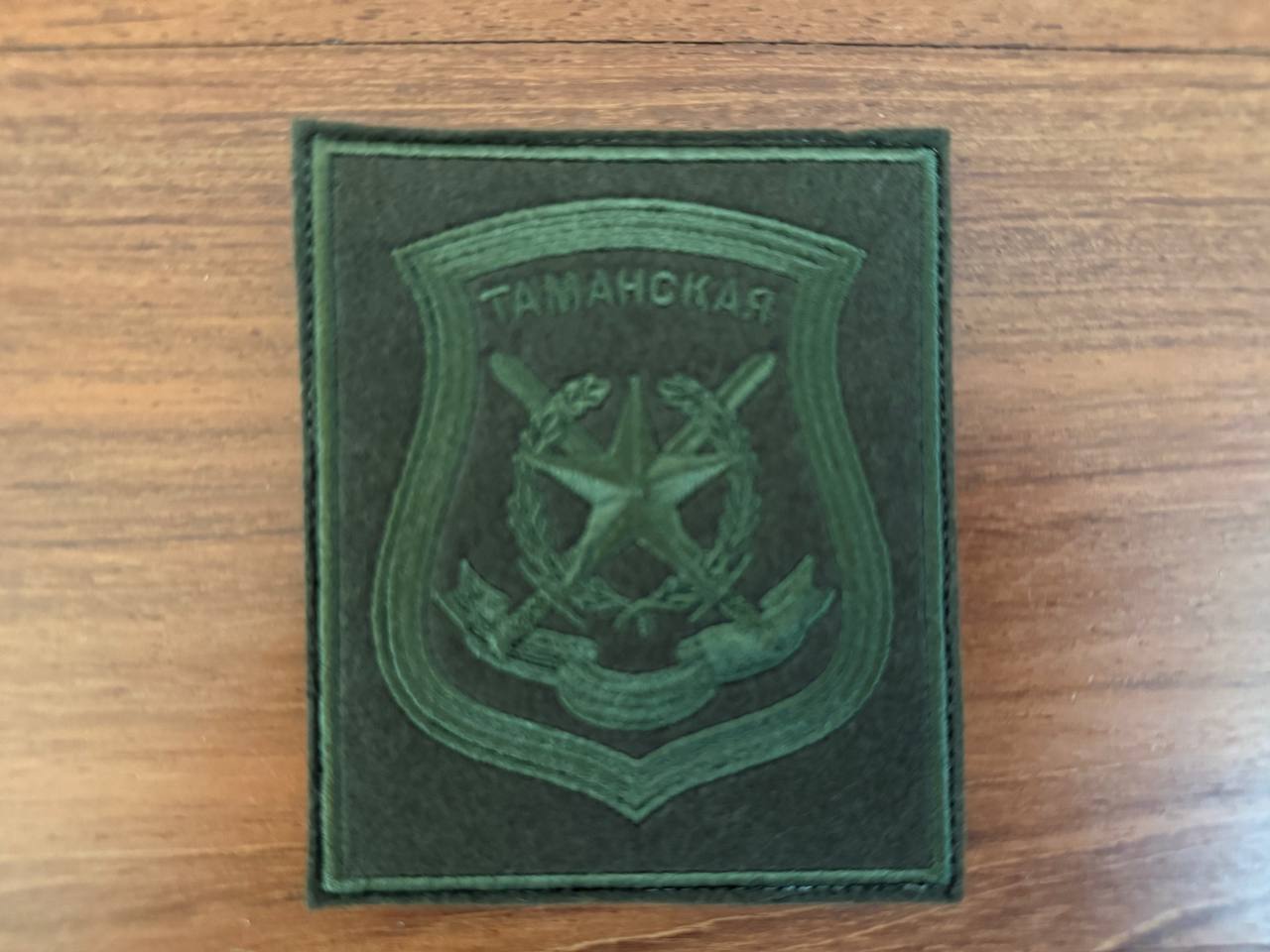 Russian 2nd Guards Motorized Rifle "Tamanskaya" Division VKBO Military Patch in dark green fabric with embroidered emblem and Cyrillic text on a wooden surface.