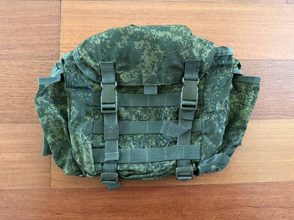 Russian Tekhinkom Buttpack (Old Gen) – EMR (Digital Flora) in green digital camouflage pattern, designed with multiple straps and buckles, laid flat on a wooden surface.
