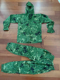 Russian SSO Partizan Sever Suit - Size 50/4 laid flat on a wooden surface, featuring green camouflage with black and beige splotches, including a hooded jacket and matching pants.