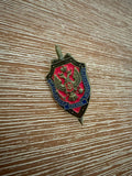 Russian FSB Pin – Shield & Sword featuring a detailed double-headed eagle emblem on a red and black shield background with Cyrillic text, representing Russian surplus craftsmanship.