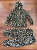 Russian 5.45 Design "Taiga" Leaf Suit – Autumn Camo - Size XL/2XL laid flat on wooden floor, featuring textured leaf-patterned camouflage jacket with hood and matching pants.