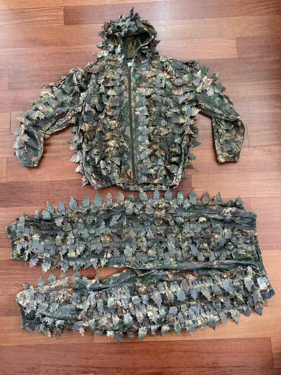 Russian Praktika Special Leaf Suit - Autumn Camo (FSB Contract) - Size 54-56/5-6 displayed flat on wooden floor, featuring a textured camouflage jacket and pants with leaf-like fabric for concealment.