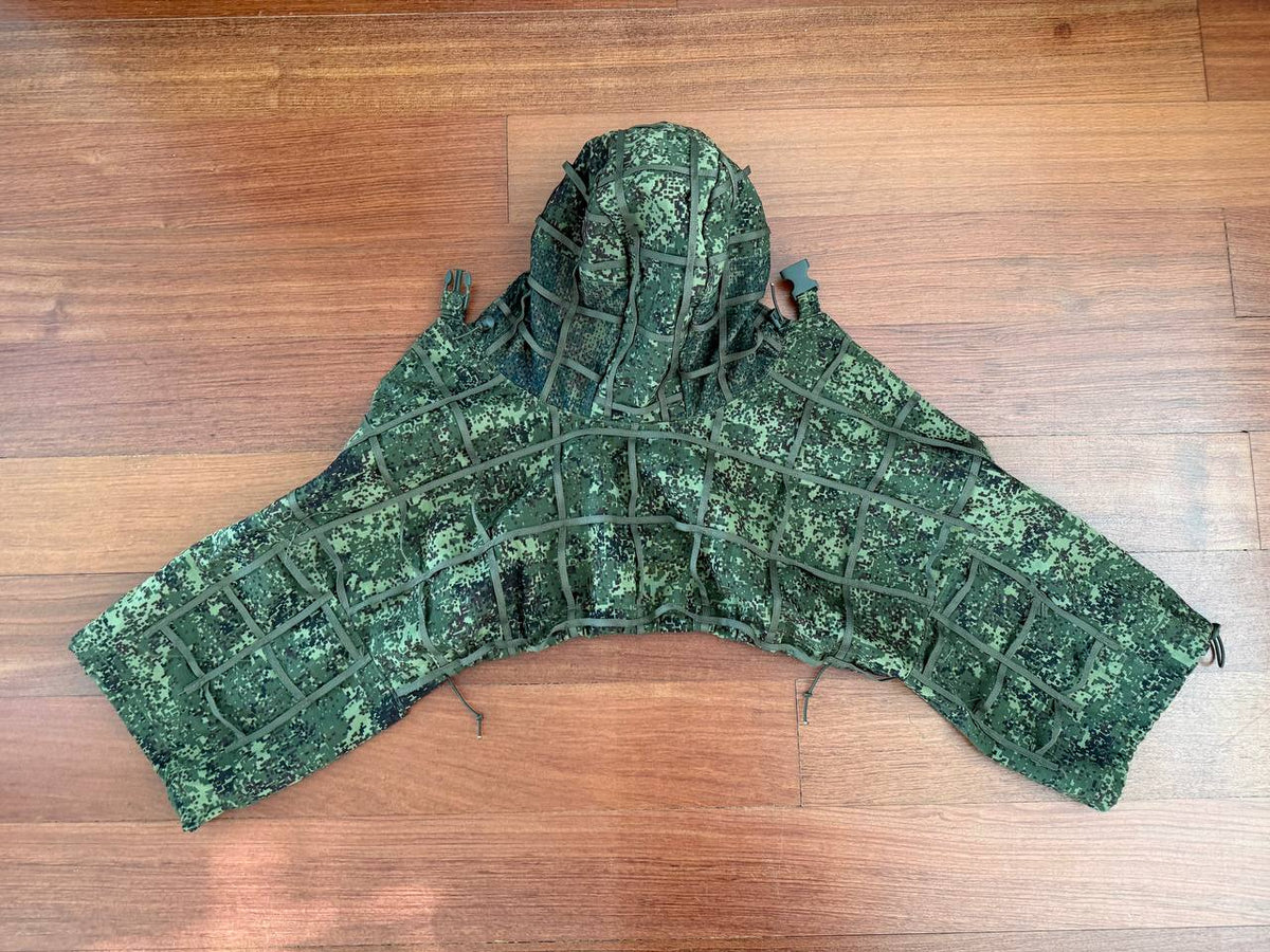 Russian Greyshop Sniper Concealment Cape – EMR (Digital Flora) laid flat on a wooden floor, featuring a digital flora camouflage pattern designed for effective sniper concealment in natural environments.