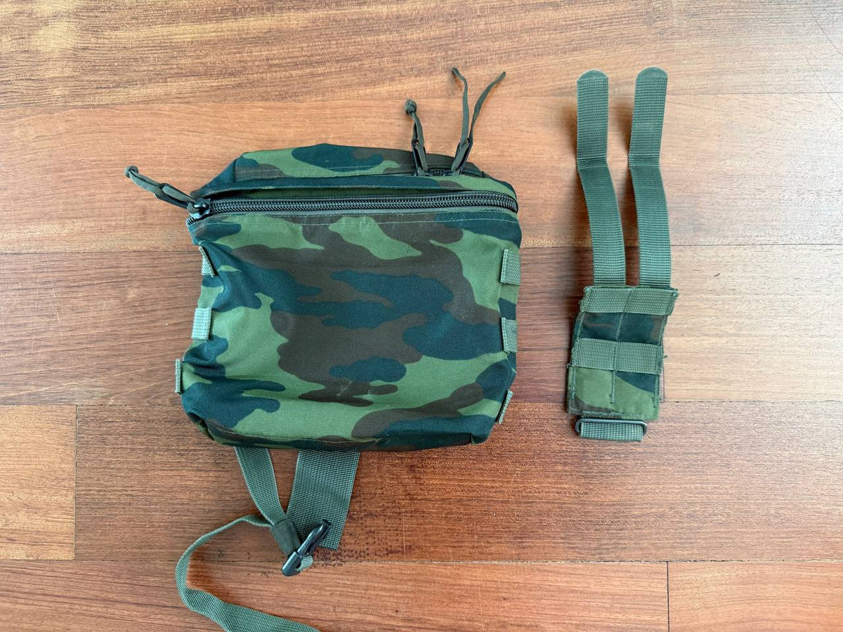Russian Tekhinkom Dump Pouch – VSR-98 Pattern displayed on a wooden surface, showing camouflage fabric with zippers and adjustable straps for tactical use.
