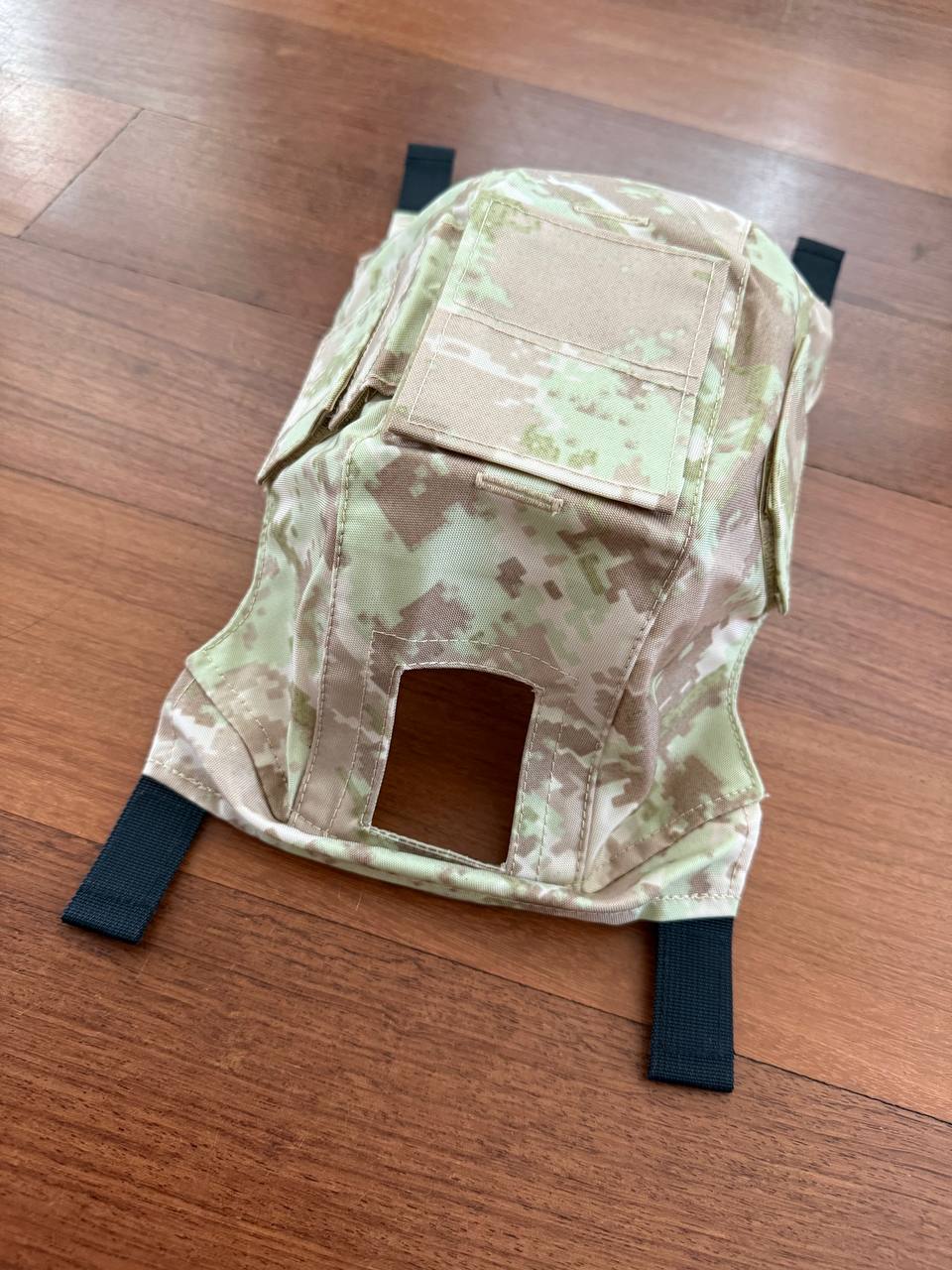Russian LSHZ Helmet Cover – Arid/Desert Pattern (Syria) Size 2 displayed on wooden floor, featuring light tan and brown camouflage with black adjustable straps.