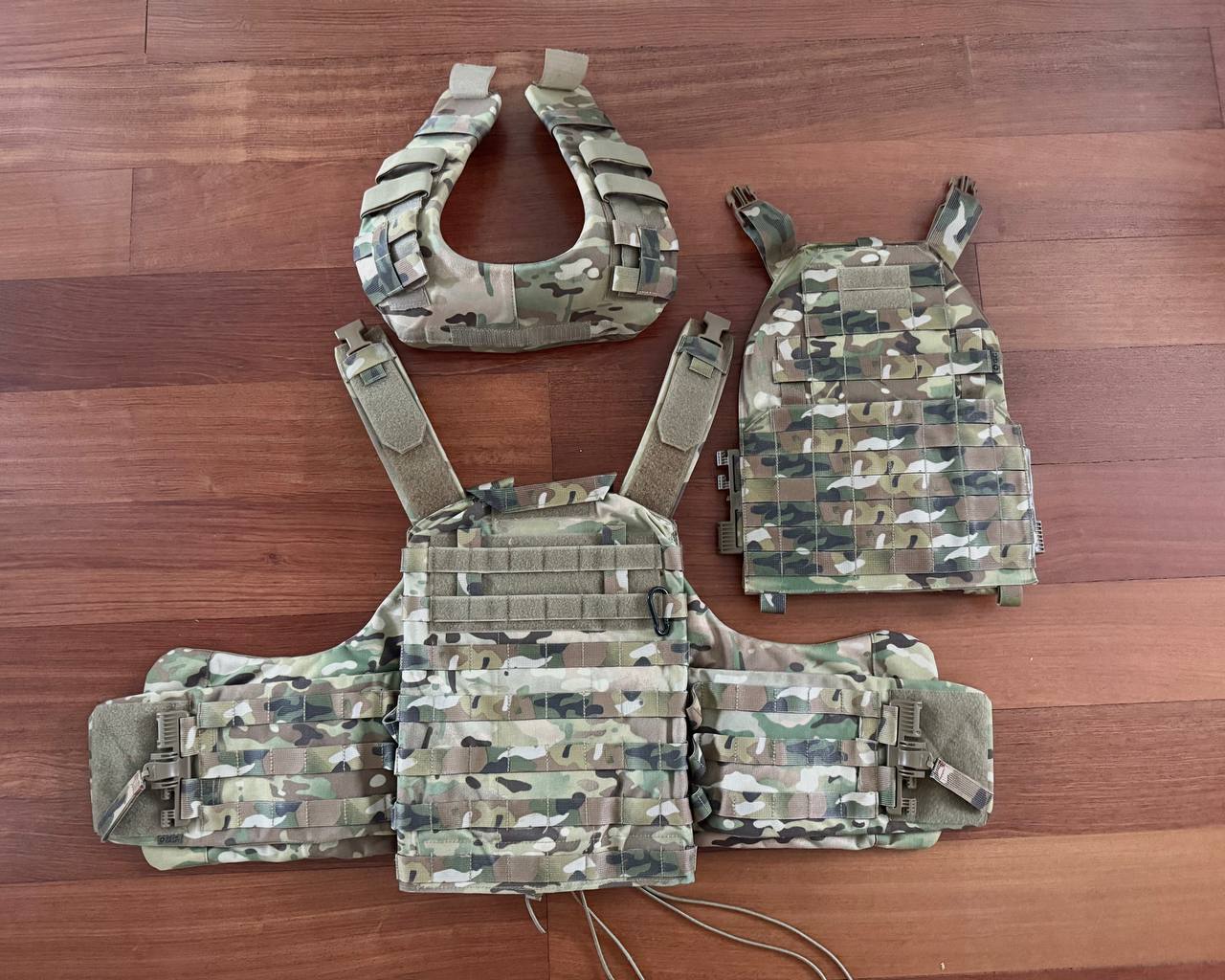 Russian Gear Craft - "Atom 1.0" Plate Carrier - Multicam - Size M displayed with modular components in a multicam pattern on wooden surface, emphasizing tactical gear design.