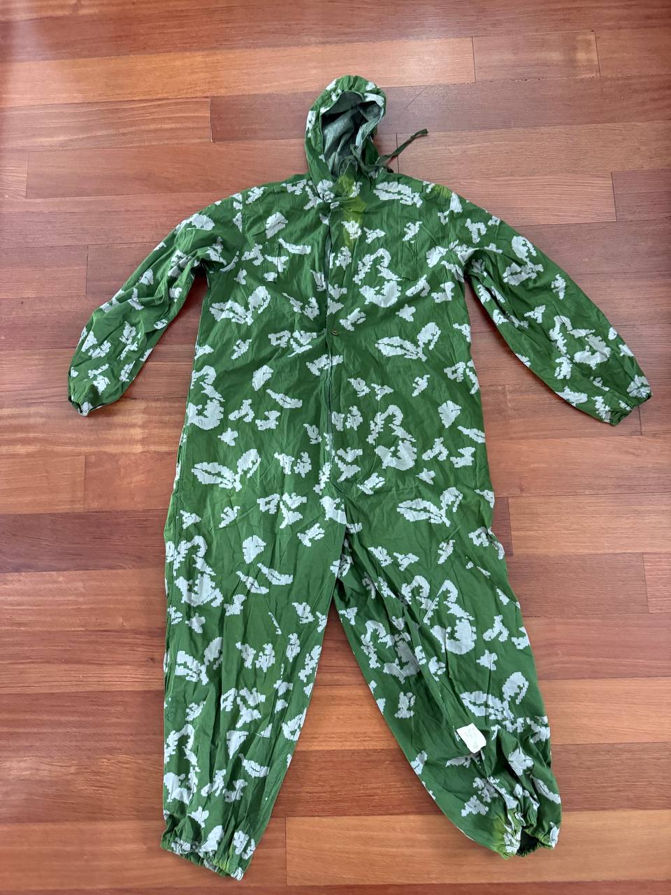 Russian "KLMK" Summer Oversuit - Size 3 displayed flat on a wooden floor, featuring a green and white camouflage pattern with a hood and elastic cuffs.