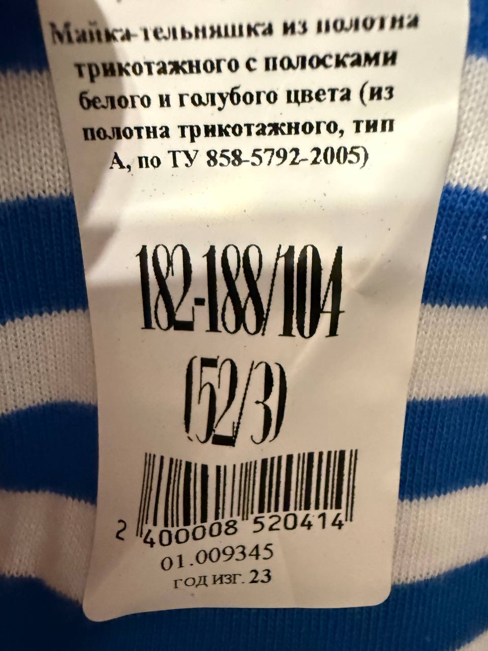Close-up of a clothing tag with size and material details on a blue and white striped fabric, showing the label for VDV Telnyashka (Russian Airborne Forces Shirt) BTK Group Size 52/3.