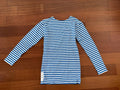 Russian BTK Group Military Telnyashka (Long Sleeve) - Size 50/3 laid flat on wooden floor, featuring classic blue and white horizontal stripes, typical of Russian surplus clothing.