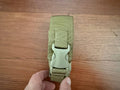 Tactical Single Grenade Pouch - Multicam in olive drab color, held by a hand, featuring durable nylon fabric and a sturdy plastic buckle closure.
