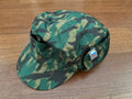 Russian NPO SM Winter Cap - Smog / Orekh Camouflage - Size 61, featuring a green and brown camouflage pattern with a small patch of the Russian flag on the side, displayed on a wooden surface.