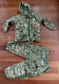Russian Sokl Leshy 4 Leaf Suit - Autumn Pattern - Size 58-60/4 displayed on a wooden floor, featuring a textured camouflage jacket with hood and matching pants in green and brown tones.