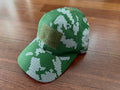 Green and white digital camouflage cap with a rectangular Velcro patch on the front, displayed on a wooden surface, featuring the Russian White Berezka KLMK Cap design.