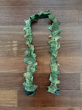 Russian Leaf Gun Stripe - 140cm - Olja Pattern laid out flat on wooden surface, featuring camouflaged fabric leaves in green shades for use as a Russian surplus accessory.