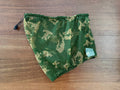 Russian SSO Net Neck Gaiter - Gold Berezka in green and beige camouflage pattern, laid flat on a wooden surface, featuring a drawstring closure and a small fabric tag.
