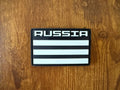 Russian Smola313 Russia Flag - Military Patch featuring a black and white striped design with the word Russia in bold letters, on a wooden background.