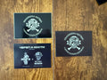 Three black cards featuring a white design of a skull wearing a military helmet with crossed bones behind it, accompanied by Cyrillic text, displaying the Russian ROTA Skull and Bones Patch from Russian surplus.