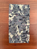 Russian Archangel of Spetsnaz Summer Buff - Multicam with a camo pattern and skull helmet design laid flat on a wooden surface, representing Russian surplus tactical gear.