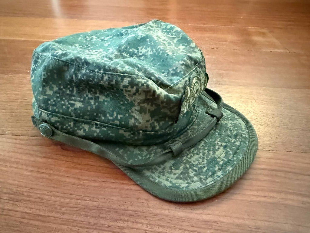 Green camouflage cap on a wooden surface