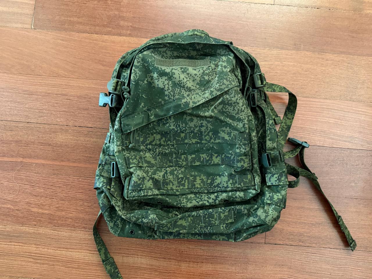 Russian Tehkinkom Big Assault Backpack - EMR Digital Flora camouflage pattern tactical military backpack laid flat on wooden floor surface.