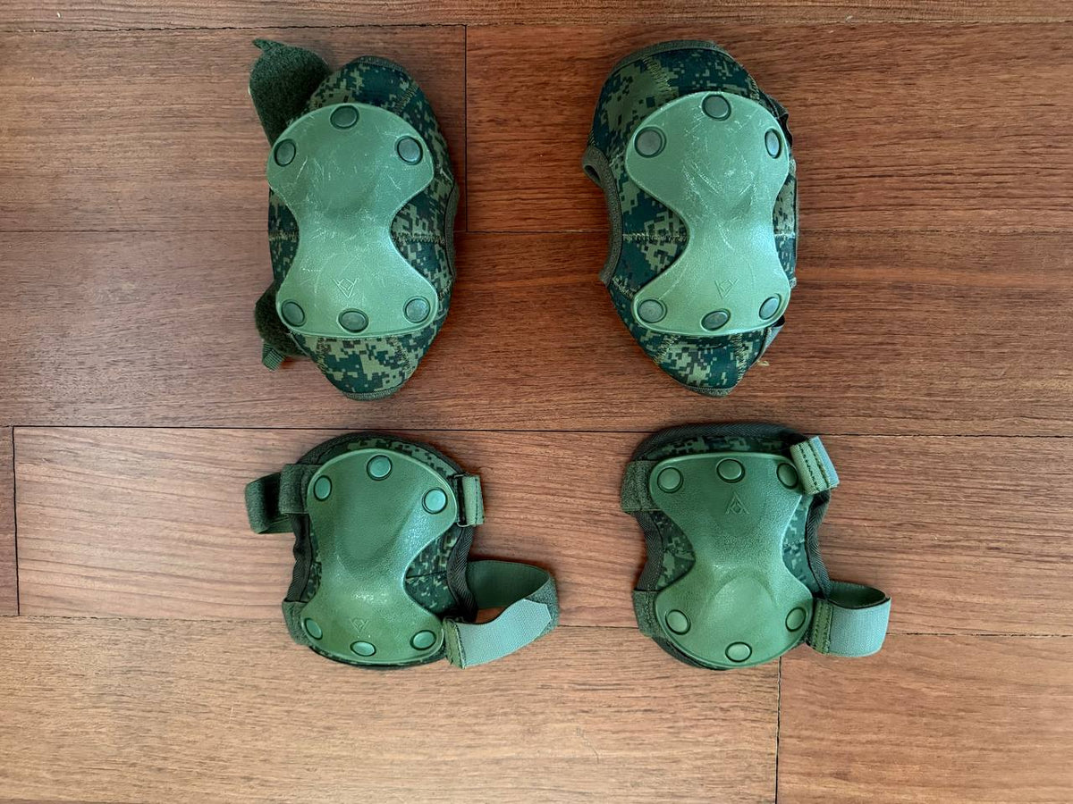 Russian 6B51 Tactical Knee & Elbow Protection Pads Set - EMR Digital Flora displayed on a wooden surface, featuring green hard plastic shells and camouflage fabric straps.