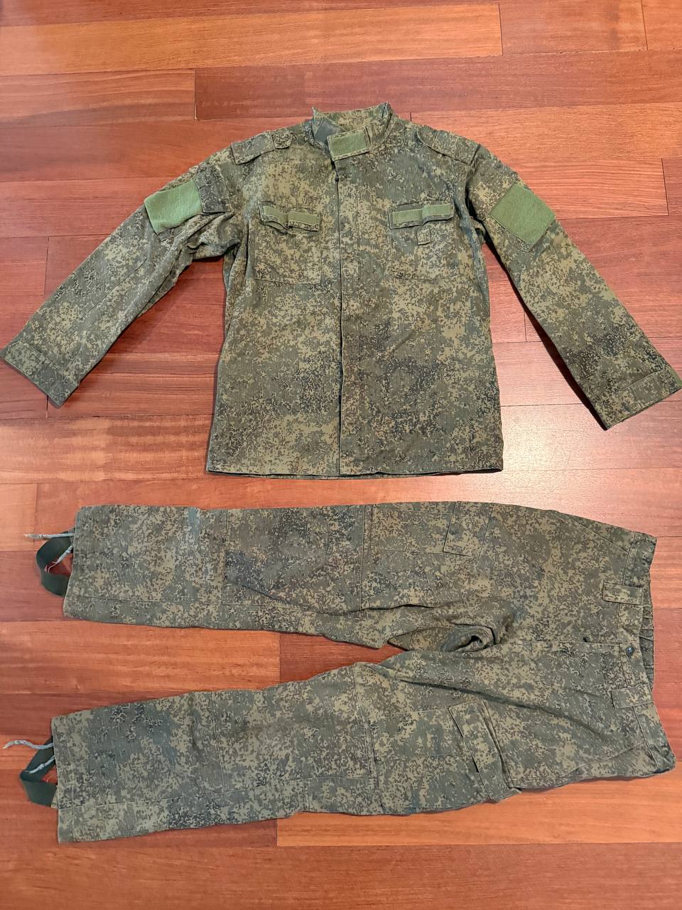 (USED) Russian Army VKPO Layer 4 Summer Suit - EMR Digital Flora - Size 52/5 displayed flat on a wooden floor, showing jacket with multiple pockets and matching camouflage pants, a piece of authentic Russian surplus.