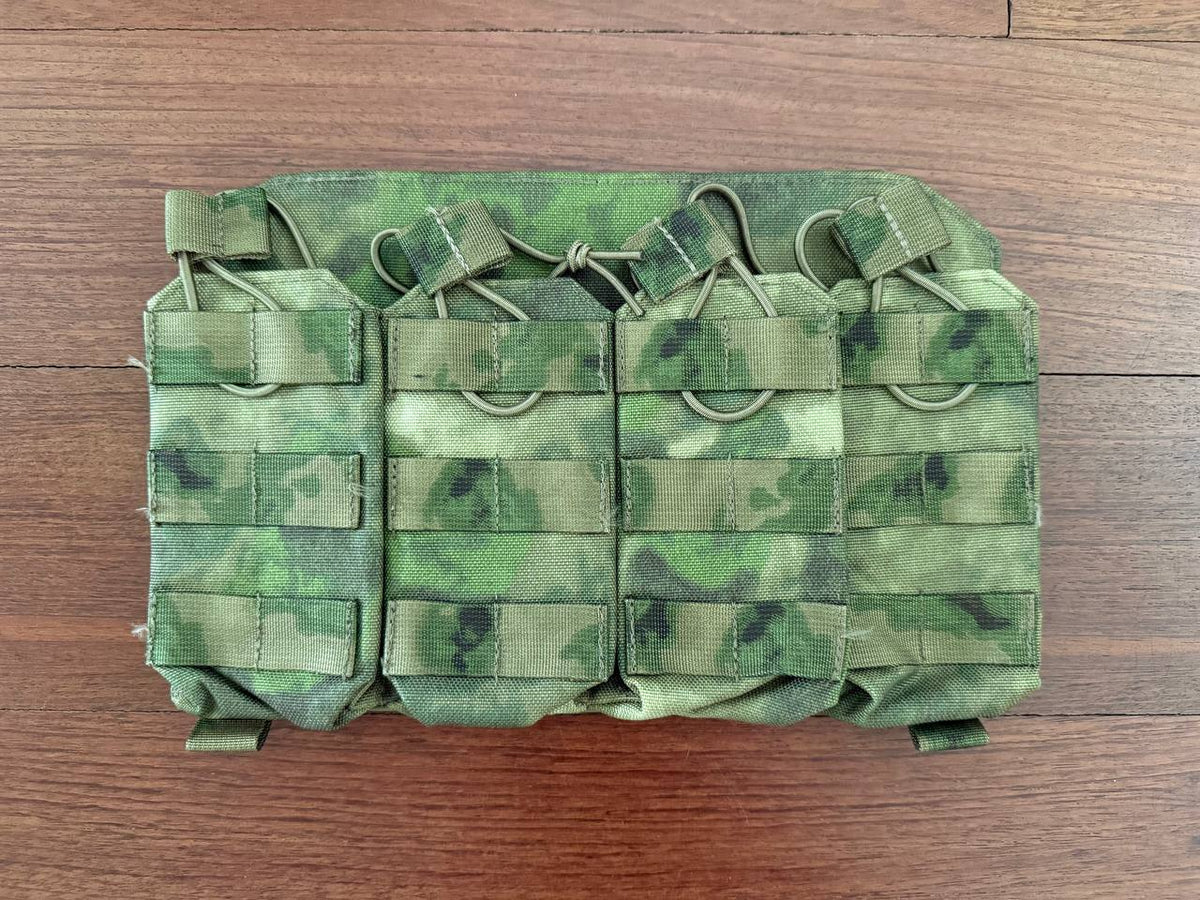 Russian Gear Craft HARD Quad AK/AR Magazine Placard - ATACS FG/Moss in camouflage pattern laid flat on a wooden surface, designed for durable magazine storage.