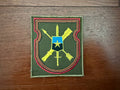 Russian 80th Independent Guards Sparta Battalion - Military Patch with green background, red and black border, featuring crossed weapons and a blue shield with a yellow star, representing Russian surplus military design.