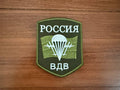 Russian Airborne Forces VDV - Military Patch featuring a green shield with white Cyrillic text, a parachute, and wings symbolizing Russian airborne troops in a Russian surplus style.