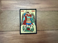 Decorative patch with an angel and dragon design on a wooden surface