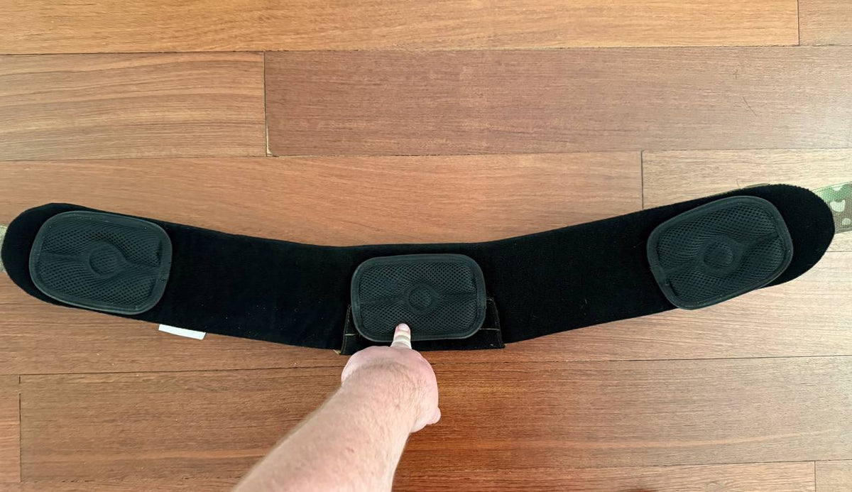 Russian ANA Tactical - "Slim" Tactical Belt - Multicam - Size M laid flat on wooden floor with a person's hand pointing to the middle buckle section, showing black padded inner side.