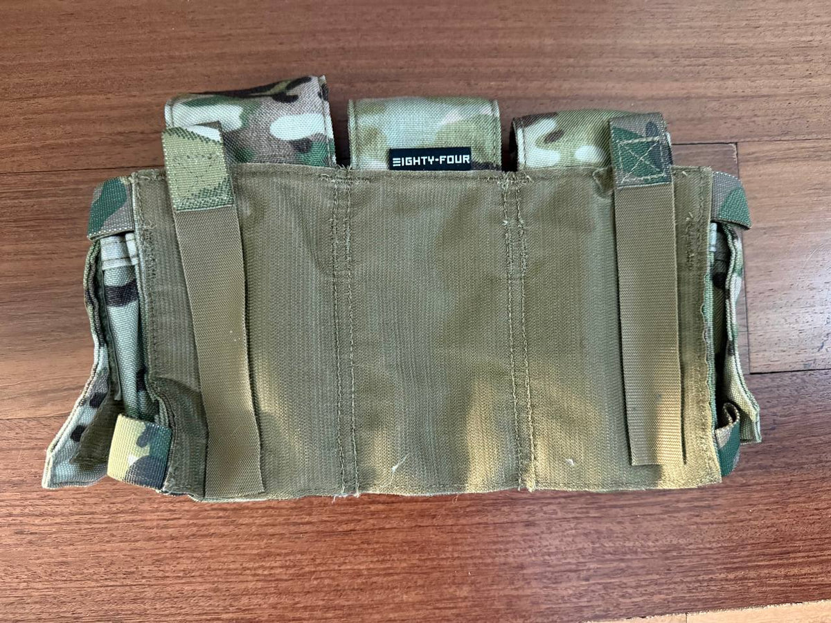 Eighty-Four - Triple Rifle Mag Placard from Kommandostore – Multicam - USED tactical gear laid flat on a wooden surface showing camouflage fabric and sturdy straps.