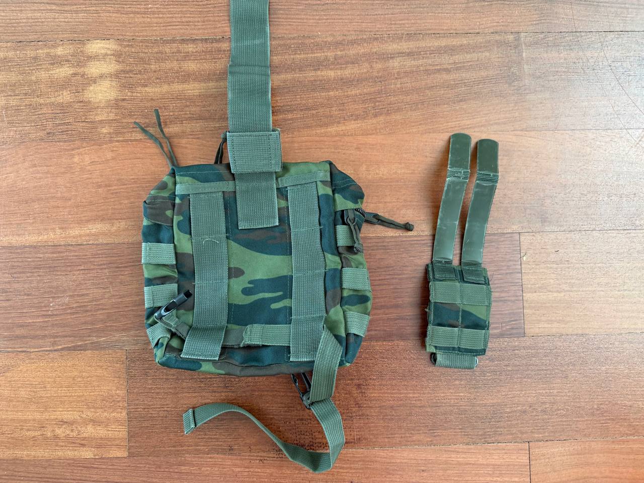 Russian Tekhinkom Dump Pouch – VSR-98 Pattern in green camouflage fabric with attachment straps, displayed on wooden surface, showcasing durable design for tactical use.