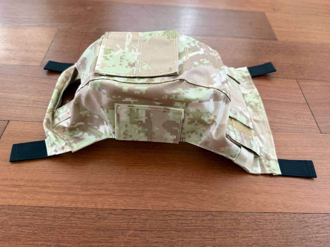 Russian LSHZ Helmet Cover – Arid/Desert Pattern (Syria) Size 2 laid flat on wooden surface, displaying adjustable straps and camouflage design typical of Russian surplus gear.