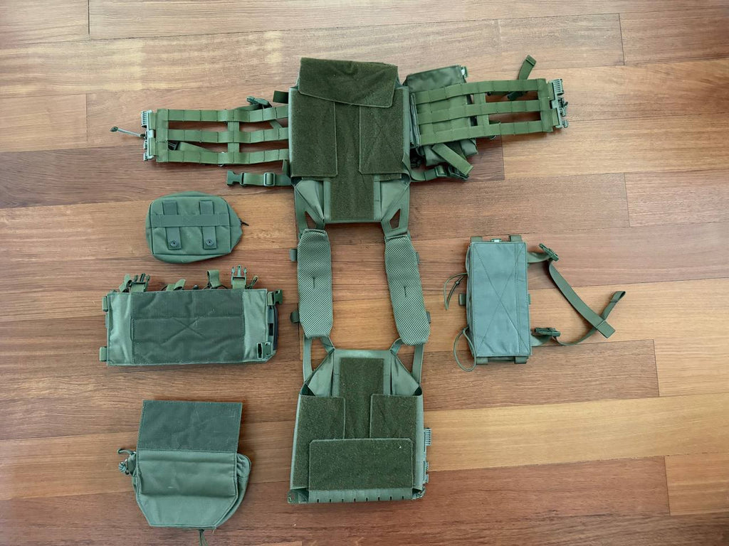 Russian MBC - "Fantom" Vest – OD Color (2018 Production) laid out on a wooden floor with detachable pouches and modular components in olive drab green, showcasing the design and storage options.