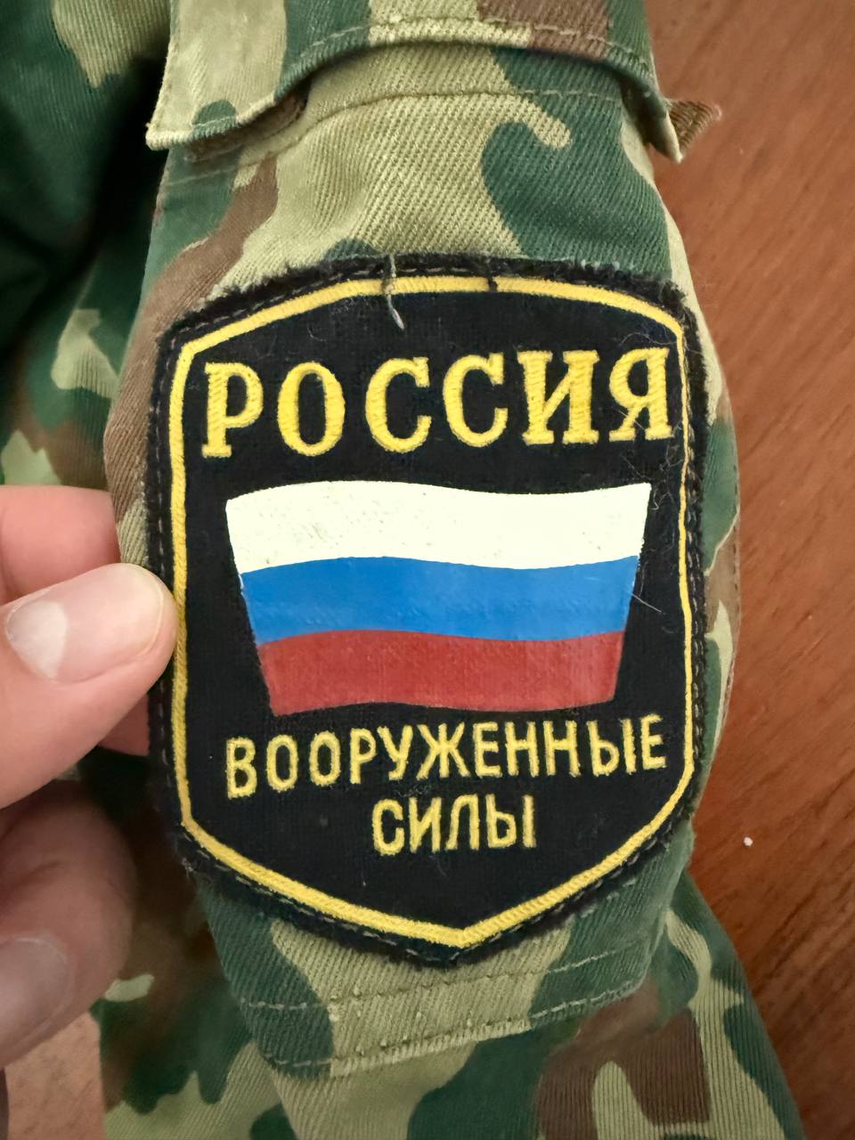 Close-up of a camouflage fabric patch featuring the Russian flag and Cyrillic text on the Russian VSR-93 Summer Jacket – Size 52/4, showing Russian surplus military design details.