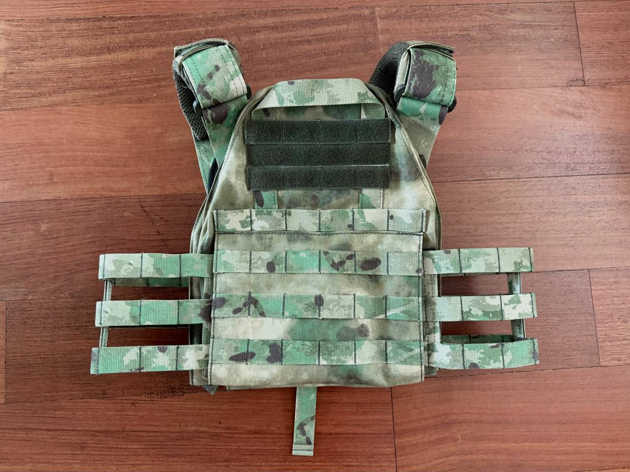 Russian Wartech TV-110 Vest - A-TACS FG Camo - Pre-War Production displayed flat on wooden floor, showing green and brown camouflage pattern with adjustable straps.