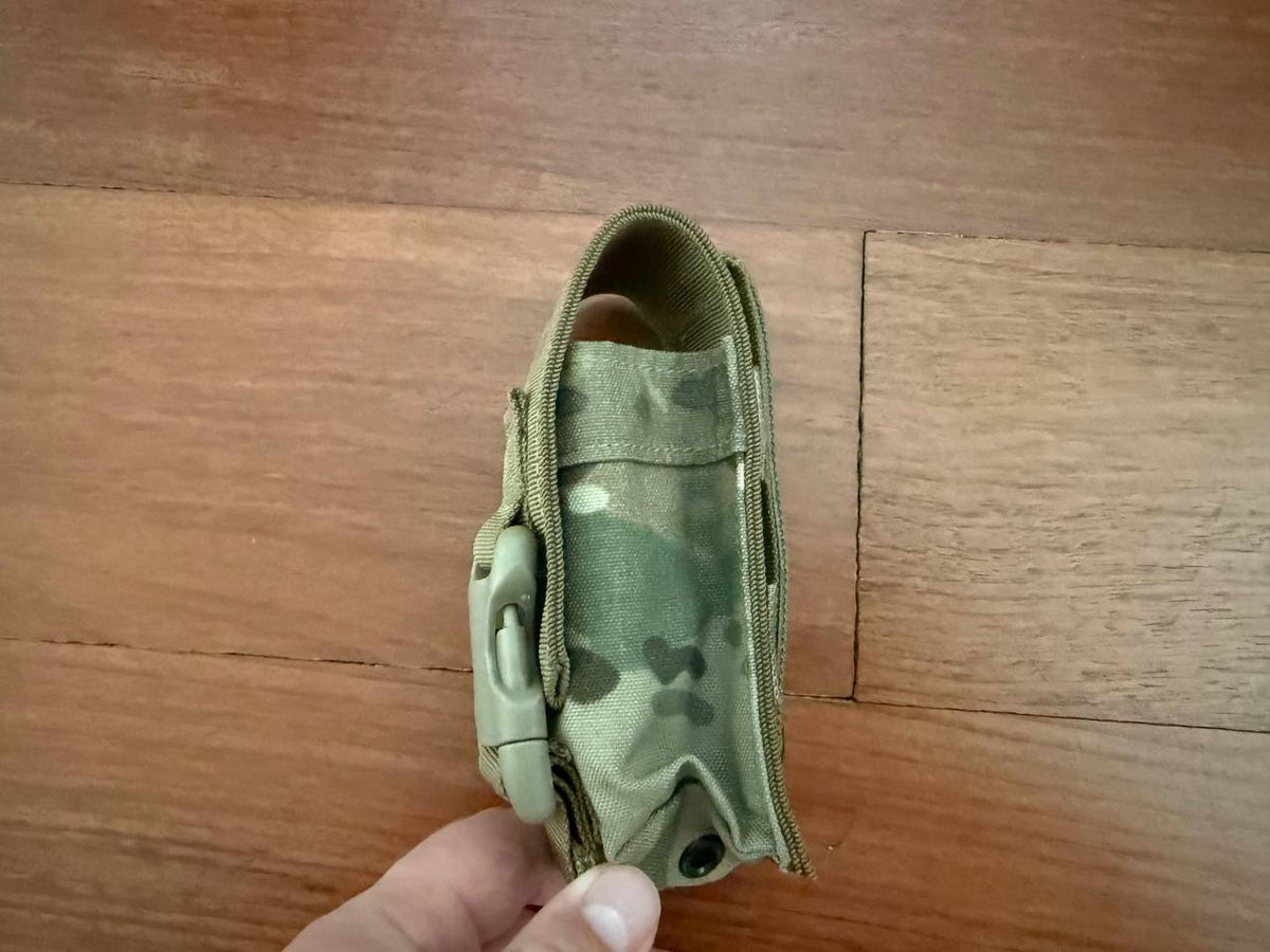 Tactical Single Grenade Pouch - Multicam shown from the side, held in hand, made of durable fabric in a multicam pattern with a secure buckle closure.