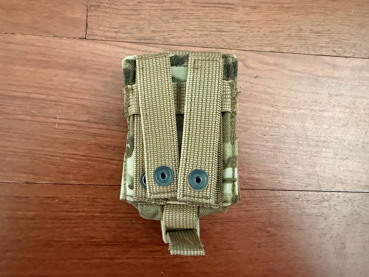 Russian Ana Tactical Single Grenade Pouch - Multicam - Old Gen FSB displayed on wooden floor, featuring durable webbing straps and secured with snap buttons for tactical use.