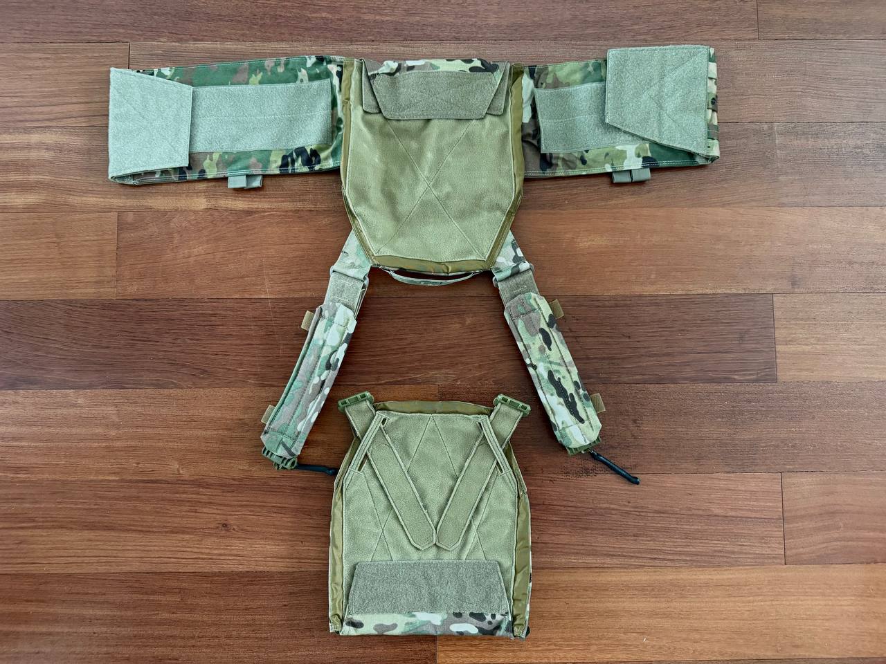Disassembled Ukrainian M-Tac Vest - Multicam laid out on a wooden floor showing its adjustable straps and camouflage pattern.